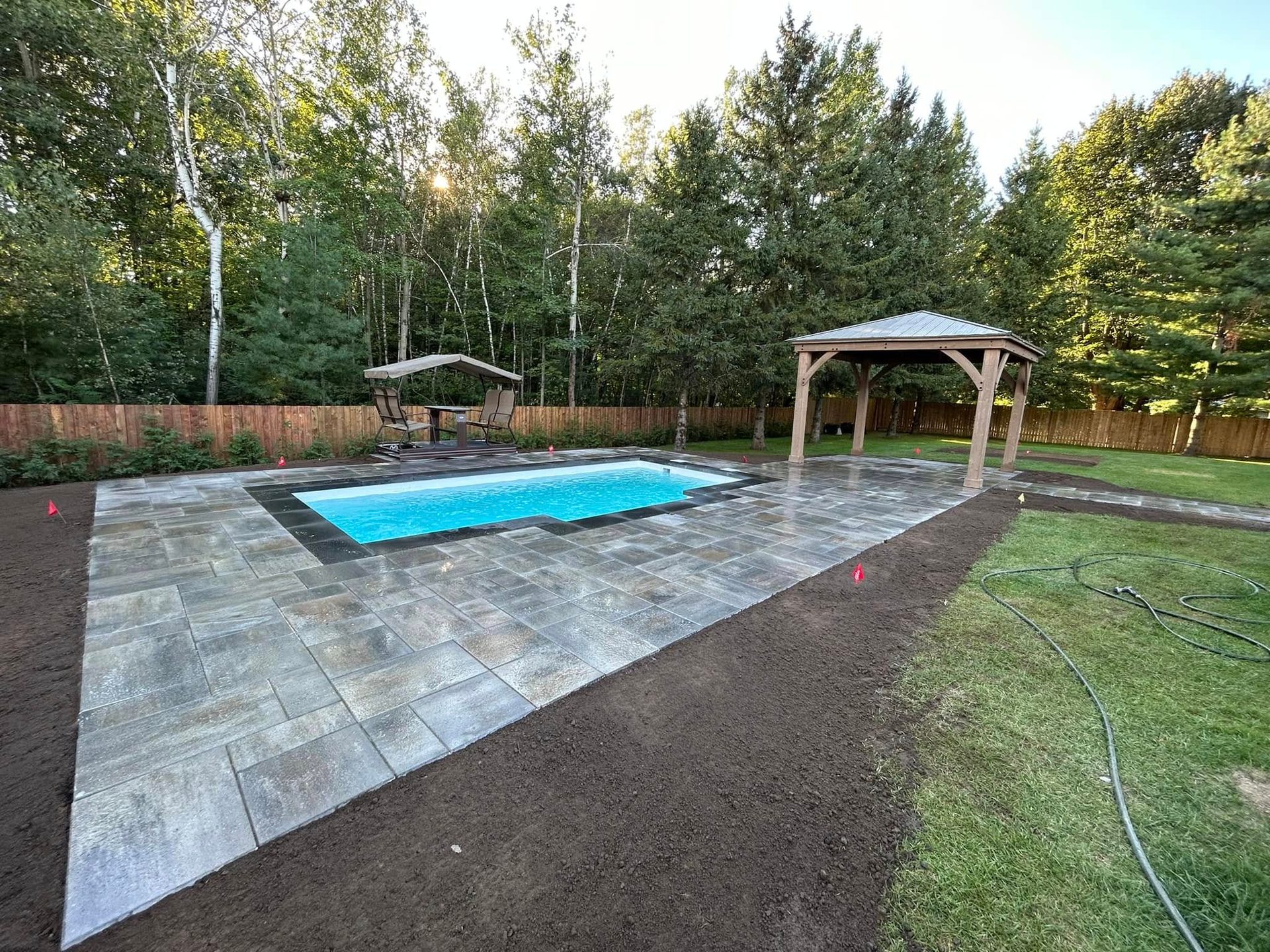 Large paver pool patio with a cedar gazebo